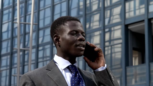 Porträt-der-erfolgreichen-zuversichtlich-schwarze-Geschäftsmann-Gespräch-per-Telefon-in-der-Straße