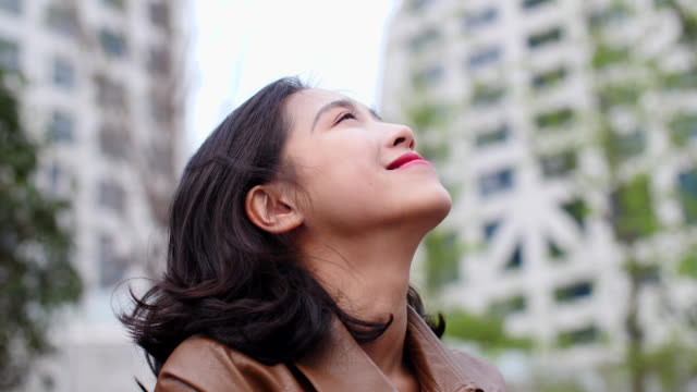 Nahaufnahme-der-hübsche-junge-Asiatin-Nachschlagen-Lächeln-in-Zeitlupe