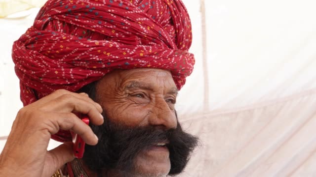 Hand-held-Rajasthani-elderly-male-on-a-smart-cell-phone-mobile-conversation