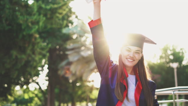 Graduated-student-raising-her-diploma-up