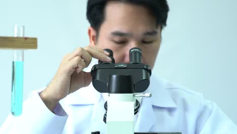 Male-scientists-looking-through-microscope-and-observe-in-modern-laboratory-or-medical-center.-Concept-of-science,-testing-development-and-lab-industry.