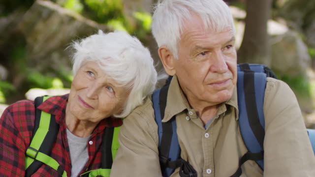 Oferta-Senior-pareja-descansando-en-el-bosque-durante-la-caminata