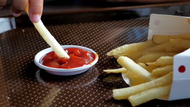 Cerca-mano-de-niño-asiáticos-comer-patatas-fritas-y-ketchup.-Video-Slow-motion