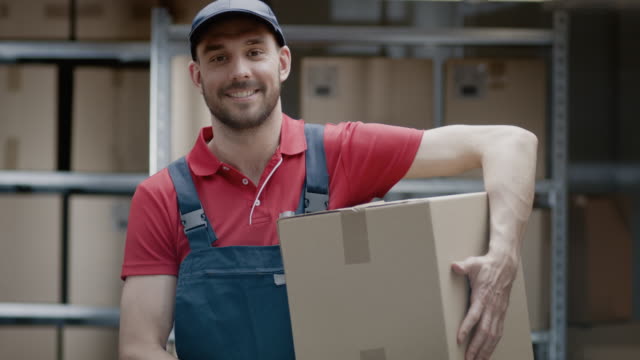 Porträt-der-schönen-Lagerarbeiter-in-Uniform-hält-Karton-Verpackung-und-lächelt.