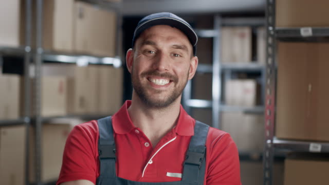 Trabajador-almacén-vestía-uniforme-cruza-los-brazos-y-sonríe.