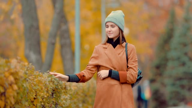 Beautiful-young-brunette-girl-walking-in-the-park-in-autumn