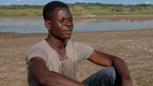 Pensive-upset-black-african-man-alone-on-the-beach--missing,family,home