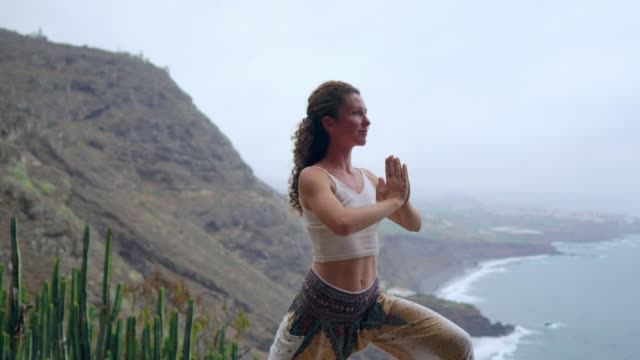 Joven-es-practicar-yoga-en-el-lago-de-la-montaña