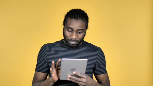 Casual-African-Man-Browsing-Internet,-Using-Tablet