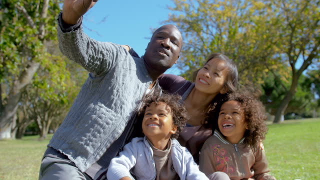 Feliz-teniendo-familia-multiétnica-selfie-en-smartphone