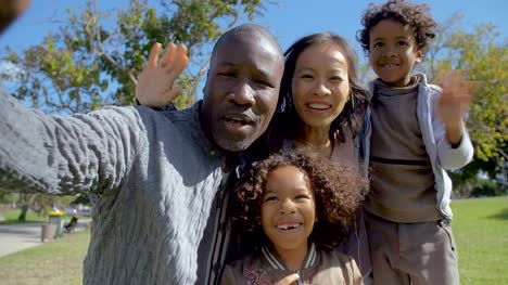 Multicultural-parents-and-children-waving-and-making-video-call