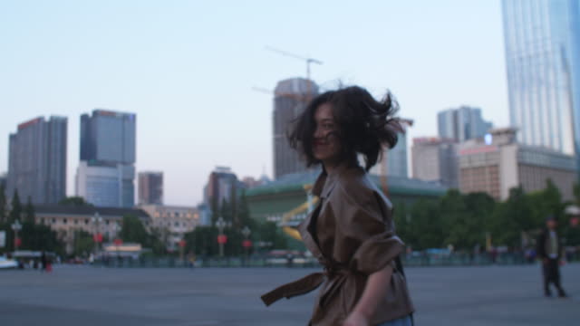 Pretty-young-asian-woman-running-in-the-city-at-evening,-4k