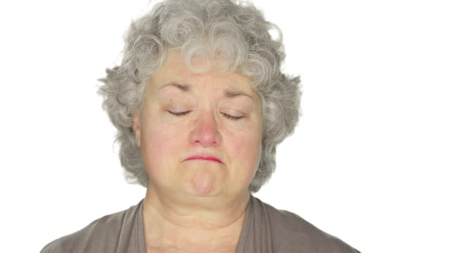 Mature-woman-fights-back-tears,-on-a-white-studio-background