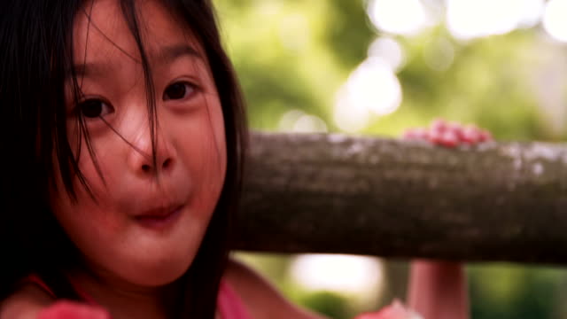 Wenig-asiatische-Mädchen-Essen-Wassermelone-in-einen-üppig-grünen-Park
