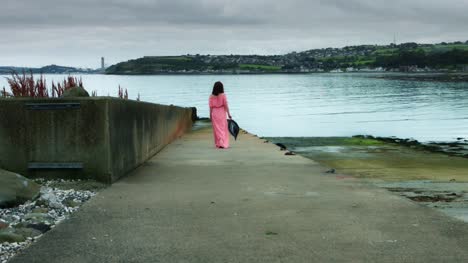 4k-Sea-View-Shot-of-a-Woman-walking-on-Harbour