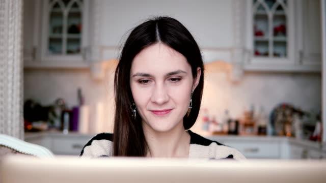 Porträt-einer-schönen-junge-Brünette-Frau-nutzt-Laptop-in-ein-helles-Esszimmer