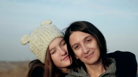 Portrait-of-happy-mother-and-teenage-daughter-smiling,-hugging,-showing-love,-waving-hands-footage.
