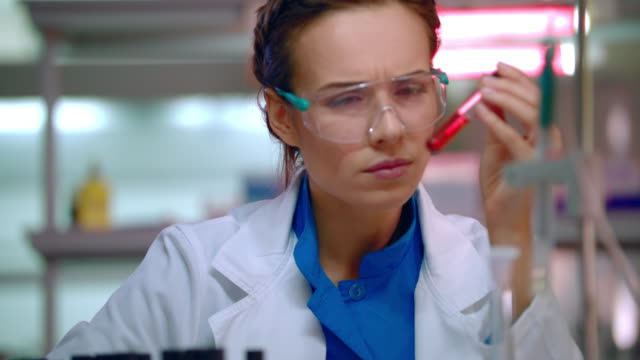 Mujer-química-haciendo-pruebas-químicas-en-el-laboratorio-de-química.-Químico-trabajando