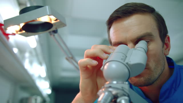 Microscopio-médico-masculino.-Cerca-de-un-médico-científico-mirando-a-través-del-microscopio