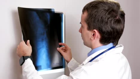 Ein-junger-Arzt-untersucht-die-Ergebnisse-der-Röntgenaufnahme-eines-Patienten-an-der-Wand.-Analysiert-den-Brustkorb-und-Rippen