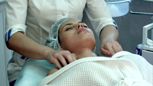 Young-woman-at-a-spa-getting-facial-and-neck-massage