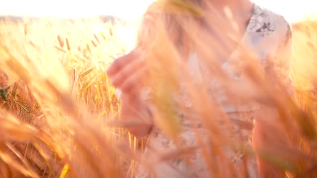 Mujer-de-pie-en-un-campo-de-oro-de-los-cultivos-de-verano