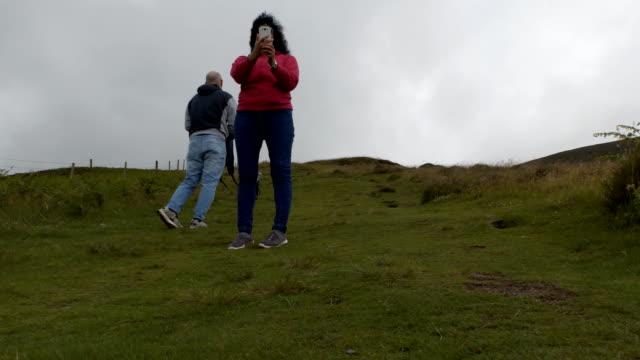 Mujer-alegre-tomando-fotos-en-la-colina