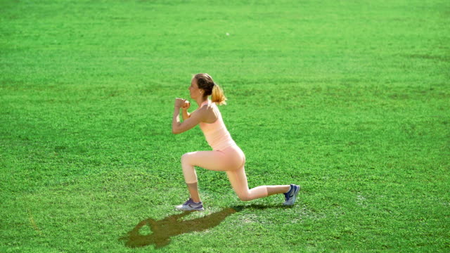 Slim-athletic-woman-doing-exercises-on-green-grass