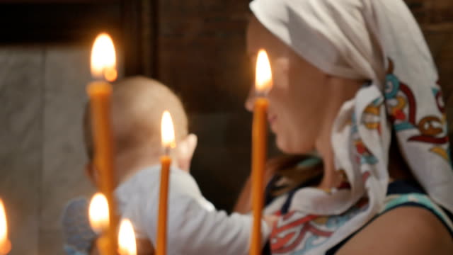 Porträt-der-jungen-Frau-mit-kleinen-Jungen-hinter-die-Kerzen-in-der-Kirche
