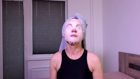 Women-with-facial-mask-on-the-face-sitting-on-bed