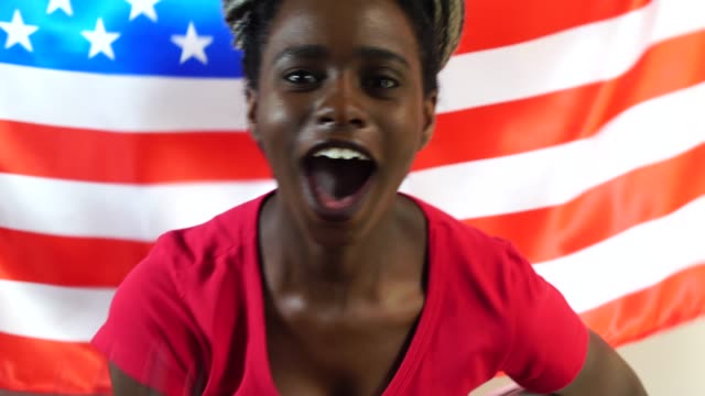 Joven-estadounidense-Black-Woman-celebrando-con-la-bandera-de-Estados-Unidos