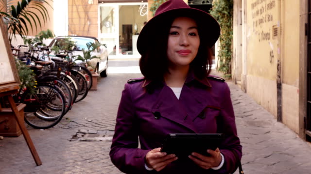Chinesische-junge-Frau-mit-digitalen-Tablet-und-Lächeln-outdoor