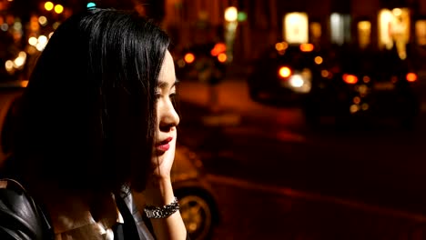 Sad,-depressed-asian-young-woman's-profile-close-up,-night-city-in-background
