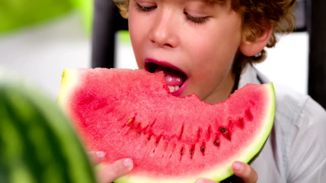 Lustige-locken-junge-isst-Wassermelone