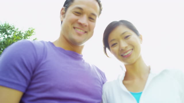 Glückliche-junge-asiatische-chinesische-Paare-im-Freien-bei-Sonnenschein