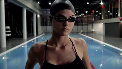 Woman-swimmer-in-goggles-making-stretching-exercise-for-swimming-in-water-pool