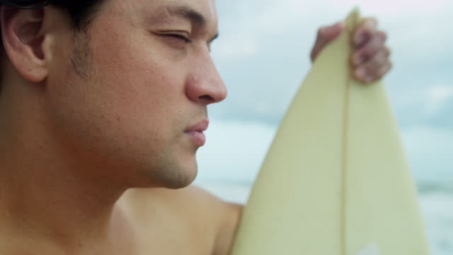 Parte-superior-del-cuerpo-asiático-chino-masculino-persona-que-practica-surf-en-la-playa