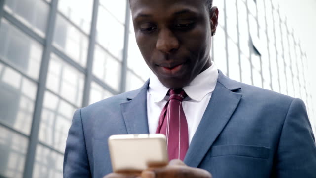 junge-schwarze-Geschäftsmann-in-der-street-Art-auf-seinem-smartphone