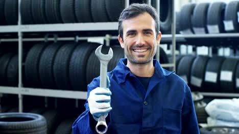 Portrait-of-a-young-beautiful-car-mechanic-in-a-car-service,-in-the-background-of-rubber.-Concept:-repair-of-machines,-fault-diagnosis,-repair-specialist,-technical-maintenance-and-on-board-computer.