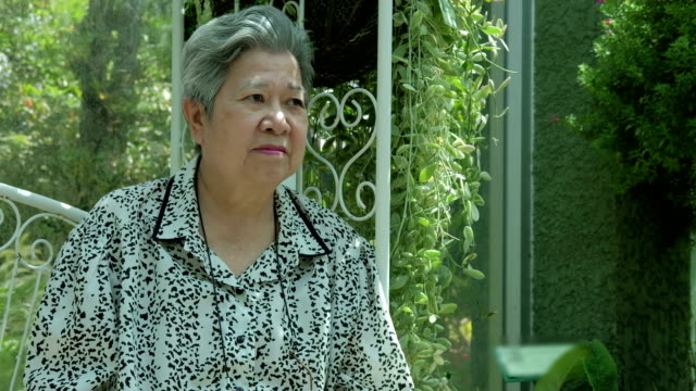 asian-elder-woman-resting-in-garden.-elderly-female-relaxing-in-park.-senior-leisure-lifestyle-outdoors.