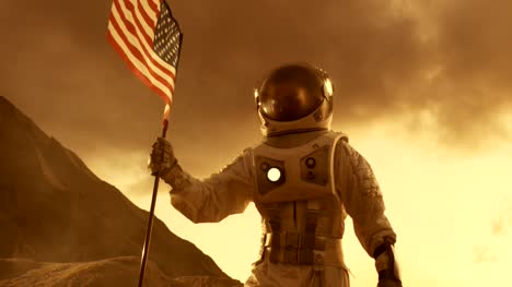 Starke-Astronaut-Spaziergänge-am-mit-einer-Flagge-vereinigt-Staaten-von-Amerika,-stolz-Pflanzen-es-auf-der-Oberfläche-des-roten-Planeten-Mars.-Raumfahrt,-Kolonisierung-Thema.