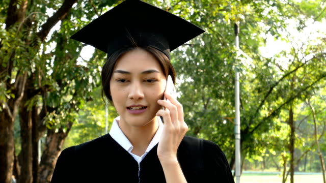 Junge-asiatische-Frau-Schüler-mit-Smartphone-für-Gespräch-mit-Freund-im-Park,-Garten-Hintergrund,-Frau-mit-Graduierung-Konzept.