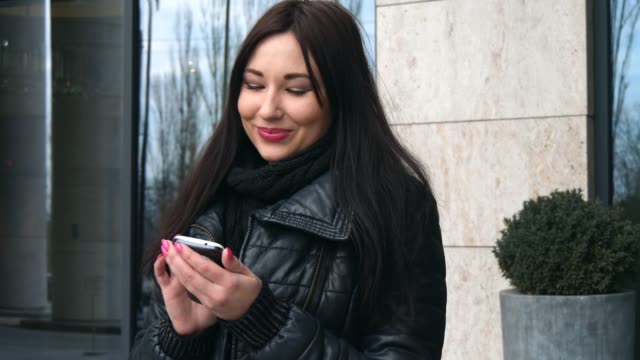 Wunderschöne-Mischlinge-Frau-mit-Smartphone-Technologie-app-zu-Fuß-durch-die-Straßen-der-Stadt-urban-glücklich