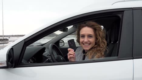 Closeup-portrait,-young-cheerful,-joyful,-smiling,-woman-holding-up-keys-to-her-first-new-car.-Customer-satisfaction