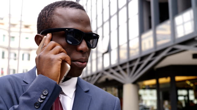 Selbstbewusst-und-erfolgreich-schwarze-Business-Mann-auf-der-Straße-per-Telefon-unter
