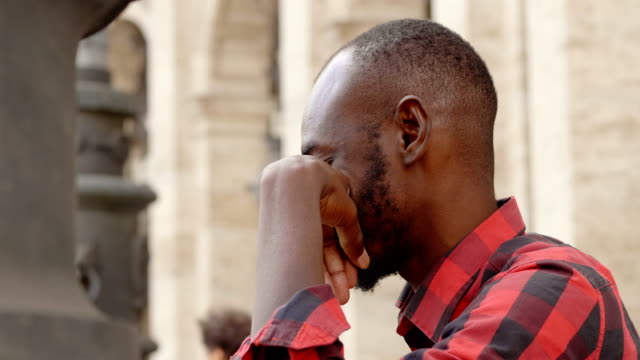 Deprimiert-und-traurig-junger-schwarzer-afrikanischer-Mann,-Profil-outdoor