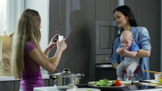 Woman-Taking-Picture-of-Female-Partner-with-Baby