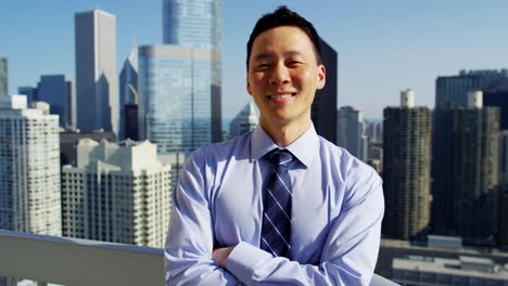 Portrait-of-Asian-businessman-on-rooftop-overlooking-Chicago