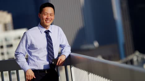 Portrait-of-Asian-American-businessman-using-touchscreen-technology