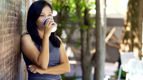 Las-mujeres-asiáticas-beben-café-caliente-en-una-cafetería-felizmente.